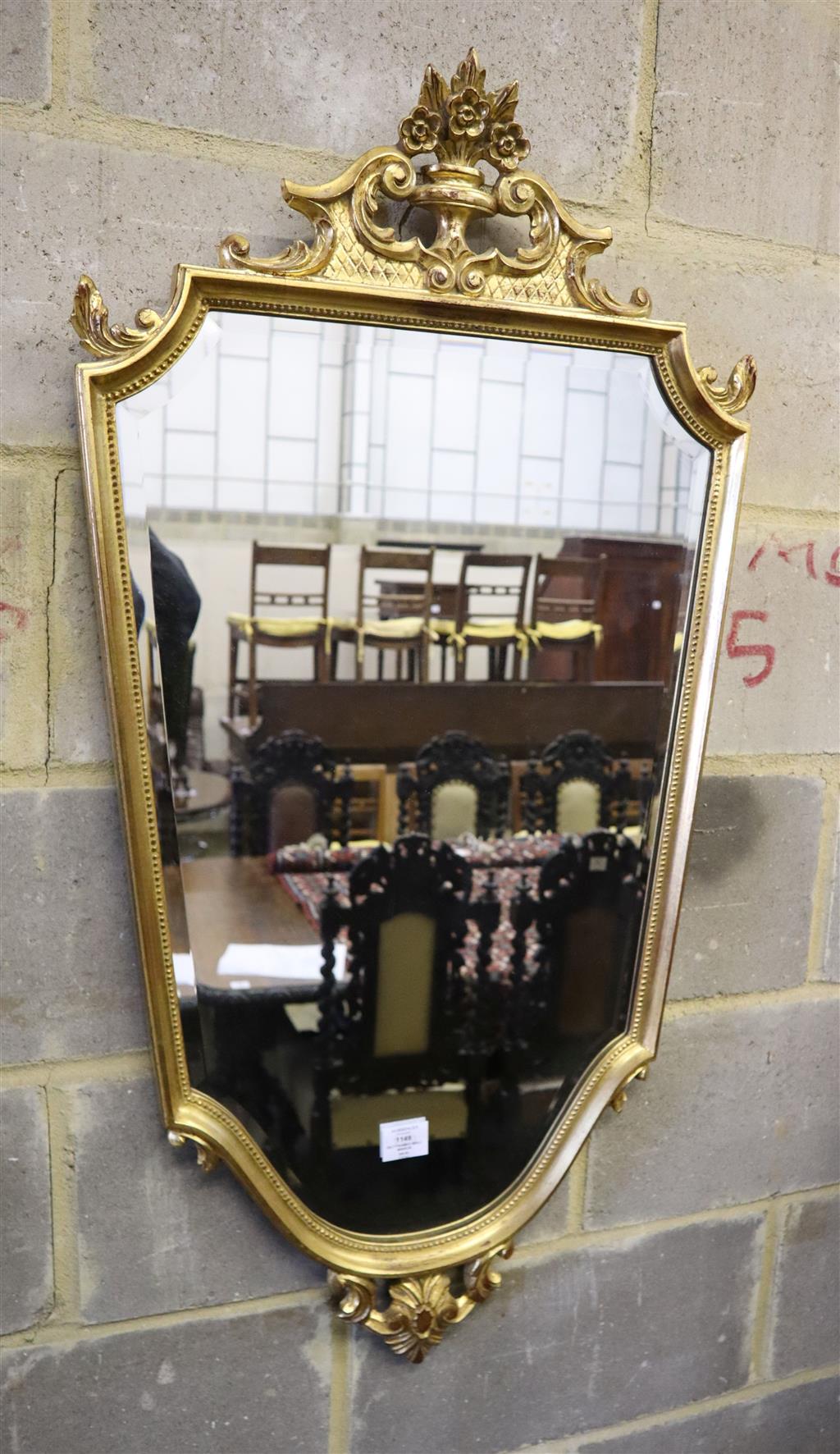 A gilt framed shield shape wall mirror, 56 x 110cm